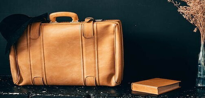 Tan suitcase with a dark background