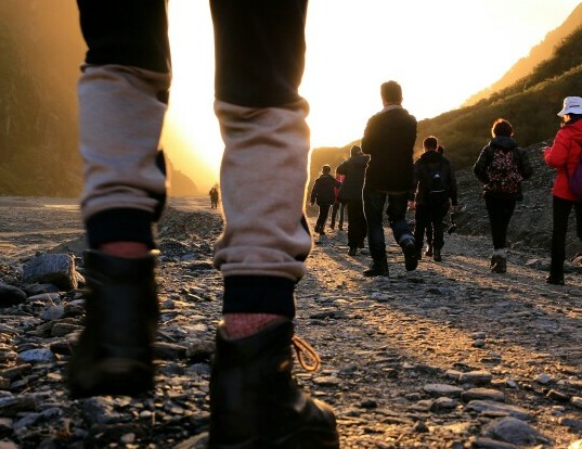 A picture of a pair of legs wearing walking/activity Trousers and hiking boots. The individual is walking up a mountain track. The image is to accompany the article by Future You Success on Burn Fat - Best Exercise to Lose Belly Fat and high light that walking is a good exercise. 