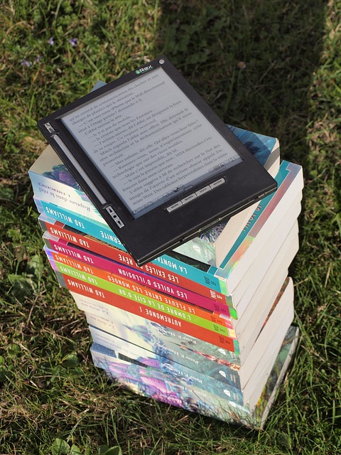 How to Start a Blog for Income; - A pile of Physical books on top of which is an E- Book Reader with a Digital Book text on the screen.