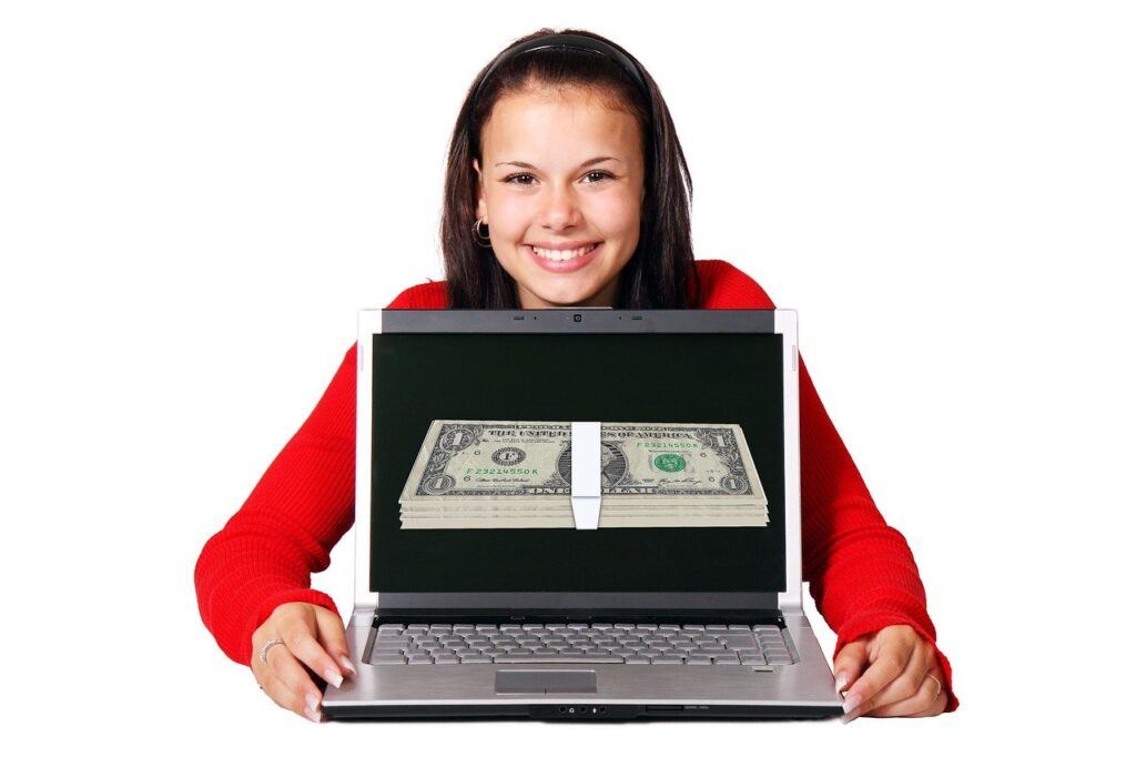 A Girl Holding a laptop computer taht is open with the screen facing us. On the screen there is a stack of Dollar Bills, emphasising earning online as per the article on Why Consider Starting a Blog by Future You Success