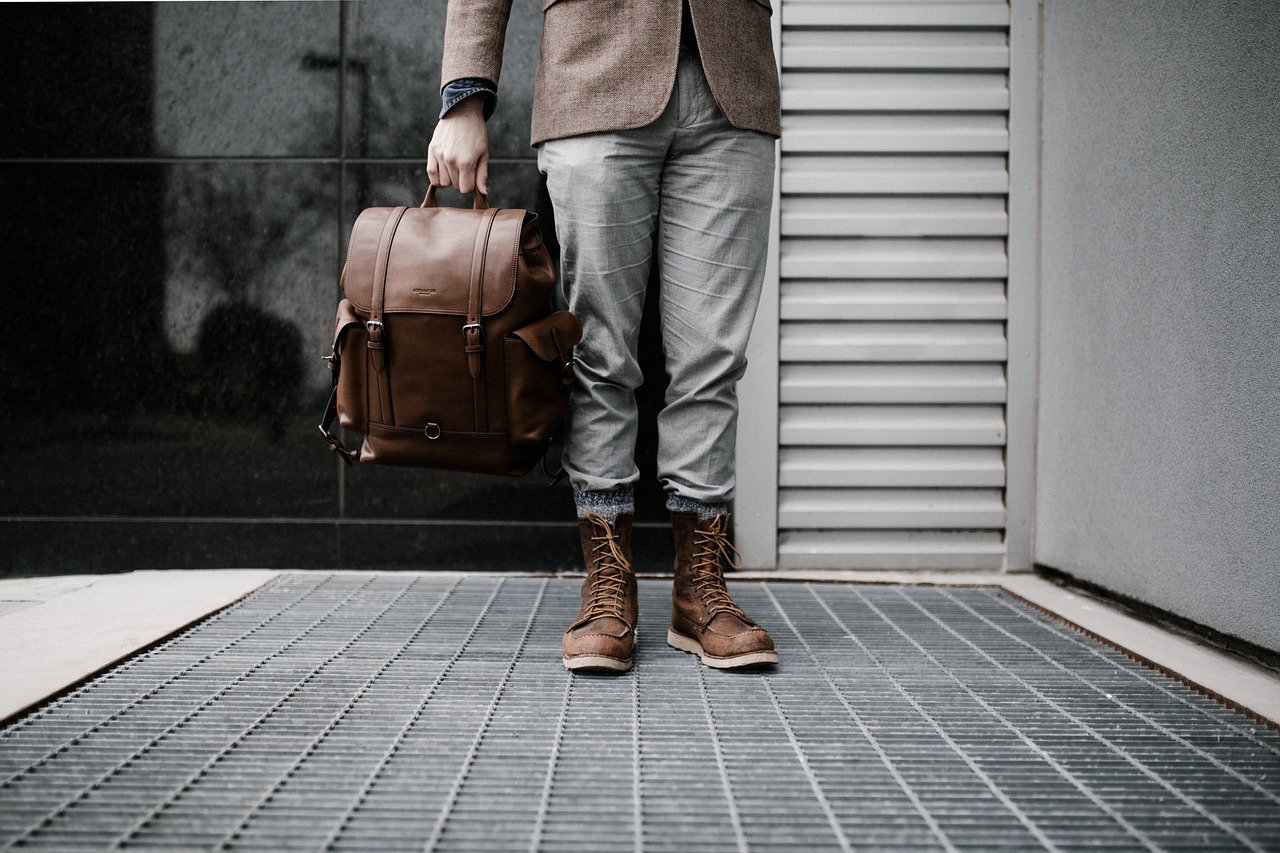 A person standing with a smart leather travel Backpack