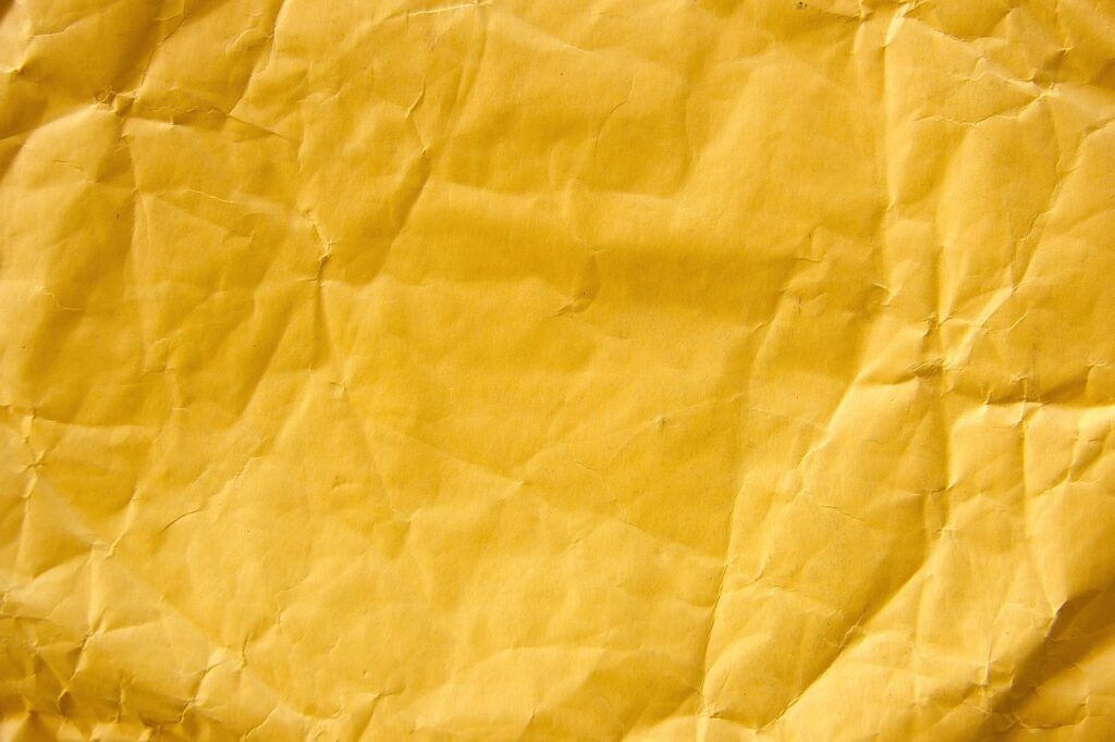 How to Pack Clothes So They Don't Wrinkle - A wrinkled and creased piece of yellow paper