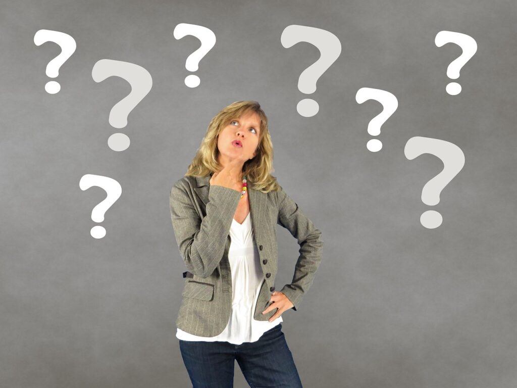 Woman Looking Up while Thinking and surrounded by floating Question Marks