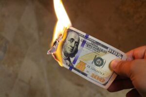 Burning Money. A Dollar Bill being held whilst it burns